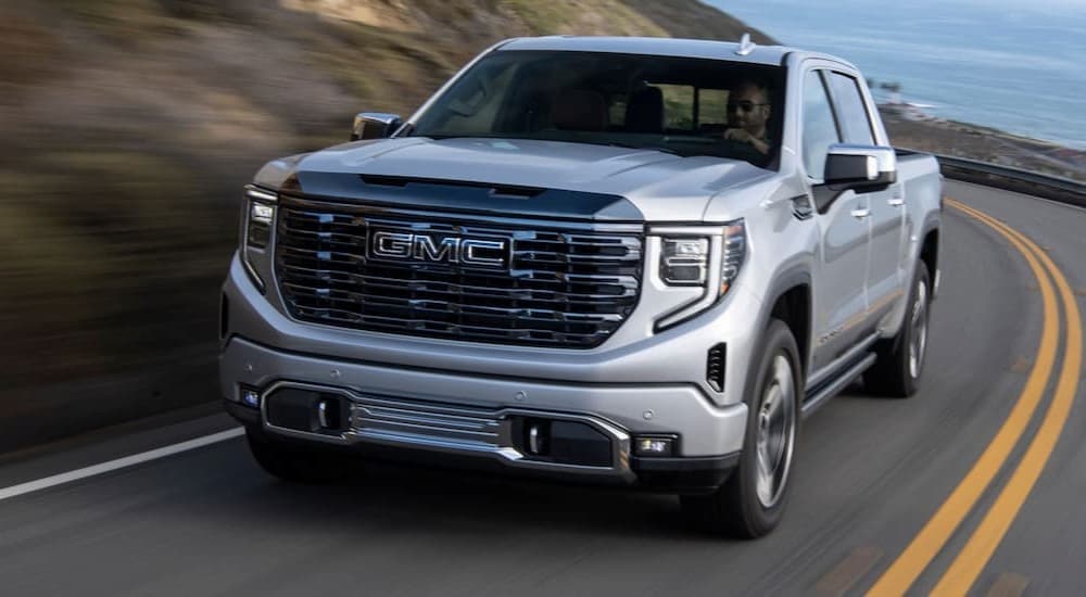 A silver 2024 GMC Sierra 1500 driving on a highway.