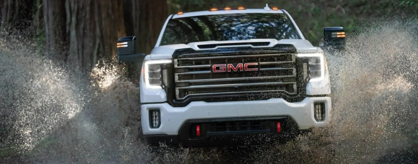White 2021 GMC Sierra 2500 HD AT4 driving off-road