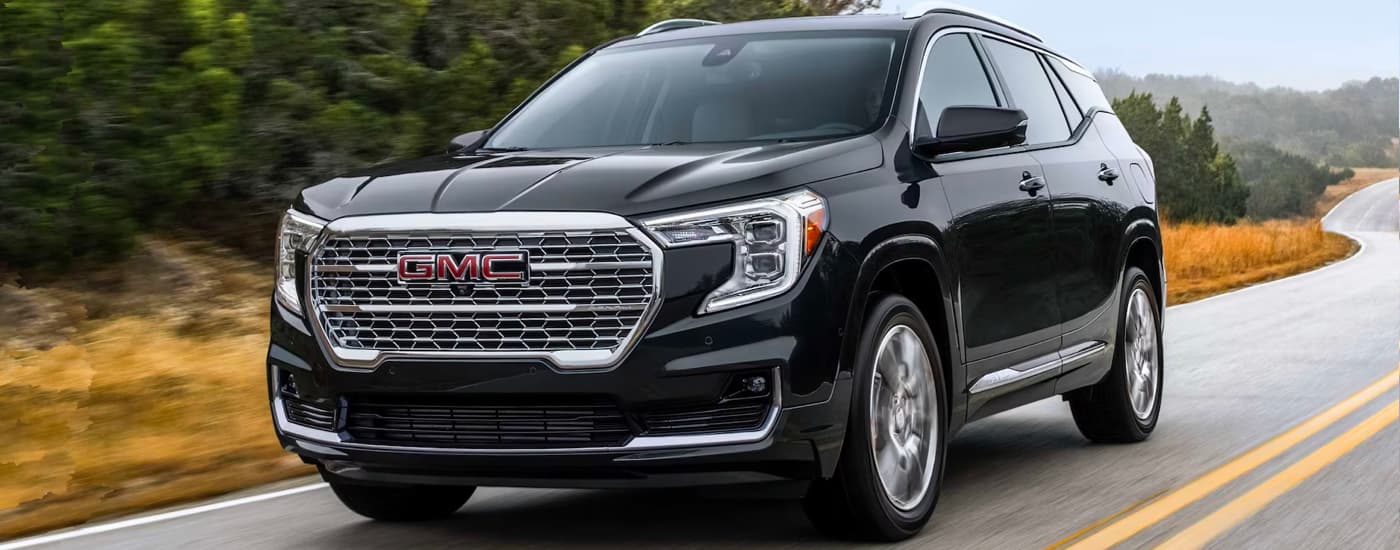 2023 GMC Terrain Denali driving down a road.