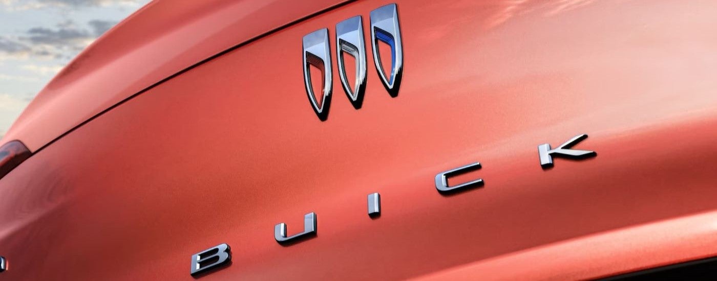 Logo badging on the rear of an orange 2024 Buick Envista ST
