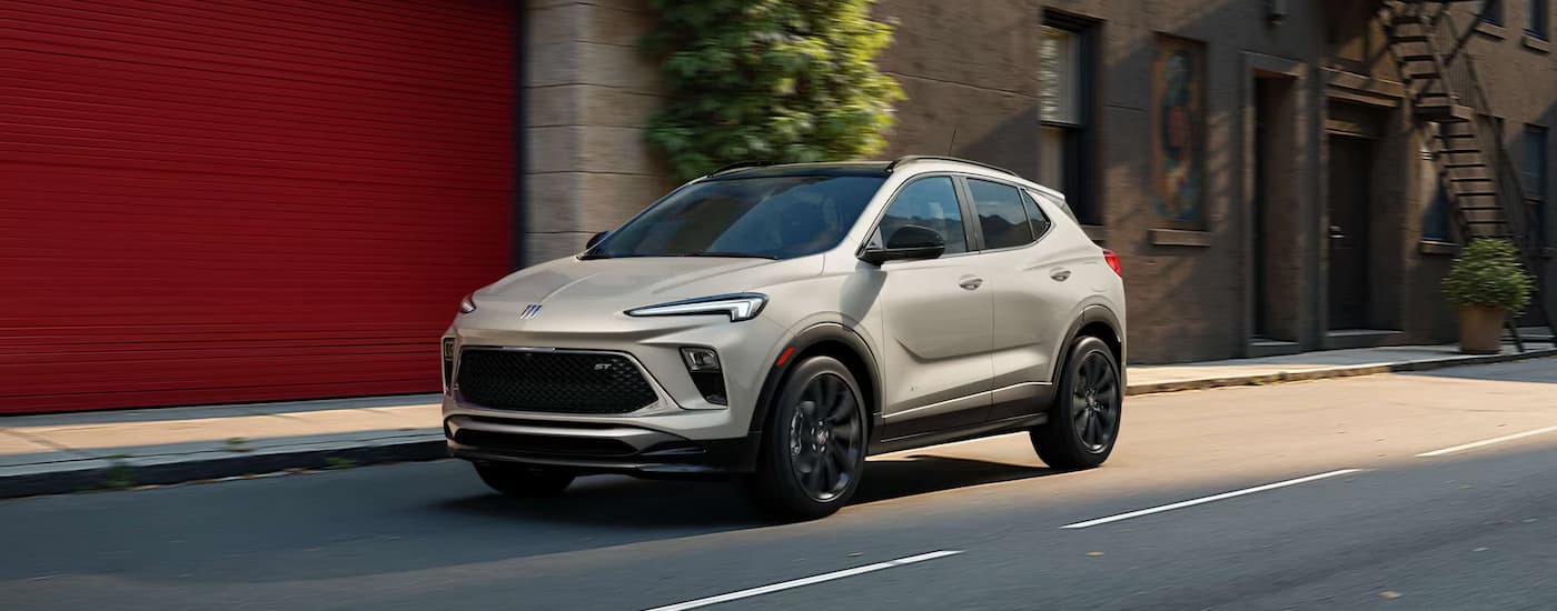 White 2026 Buick Encore GX driving down a city street.