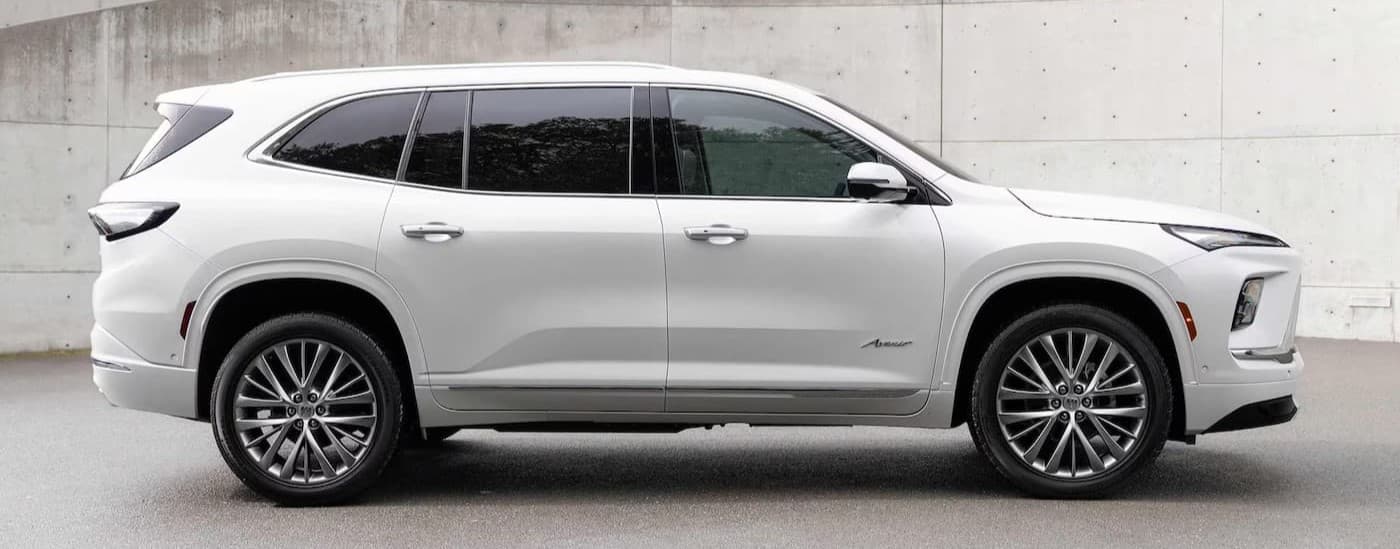 A white 2025 Buick Enclave Avenir parked near a Buick dealer in Rockwall.