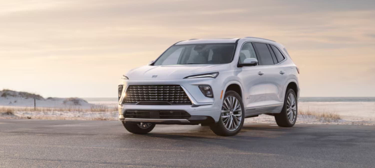 A white 2025 Buick Enclave parked near sand.