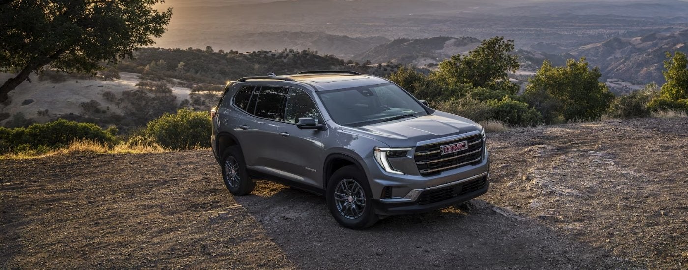 A grey 2025 GMC Acadia Elevation is parked near an overlook.
