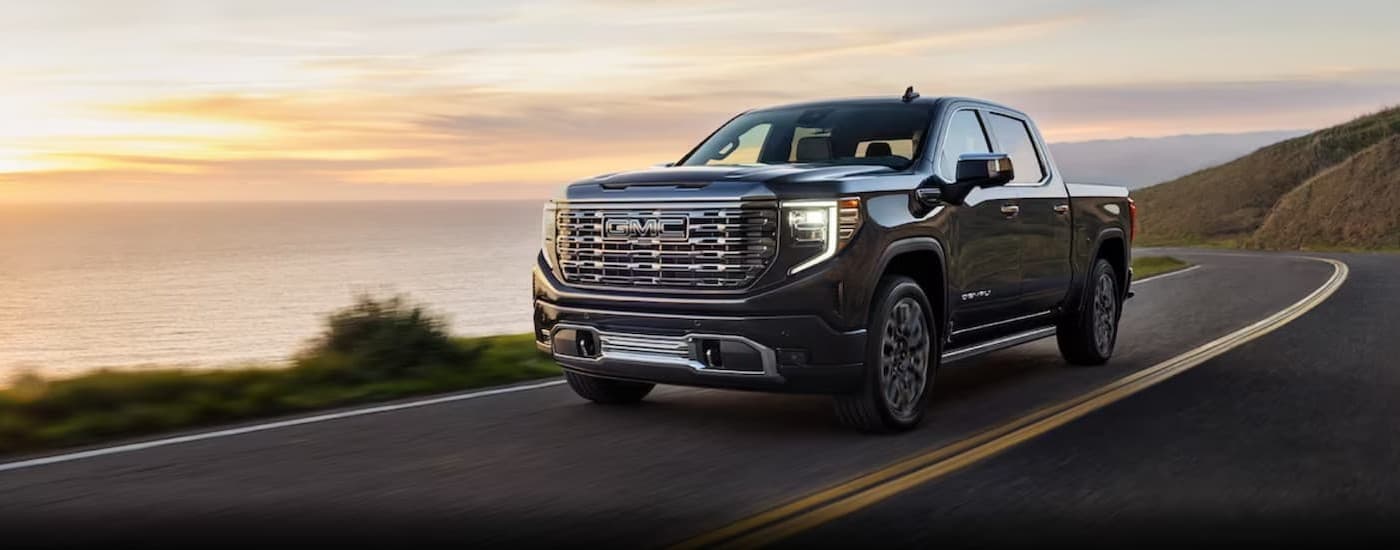 A gray 2024 GMC Sierra 1500 driving on a highway.