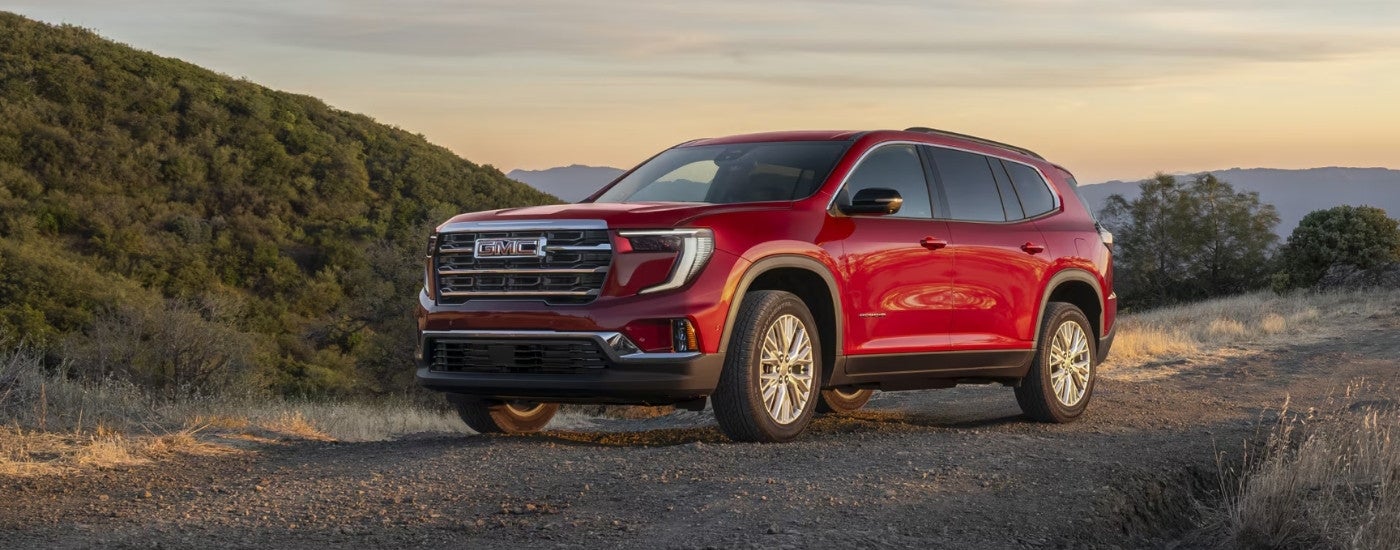 A red 2025 GMC Acadia parked off-road