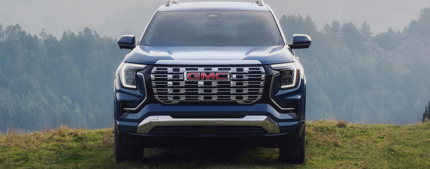 A blue 2025 GMC Terrain Denali parked on grass