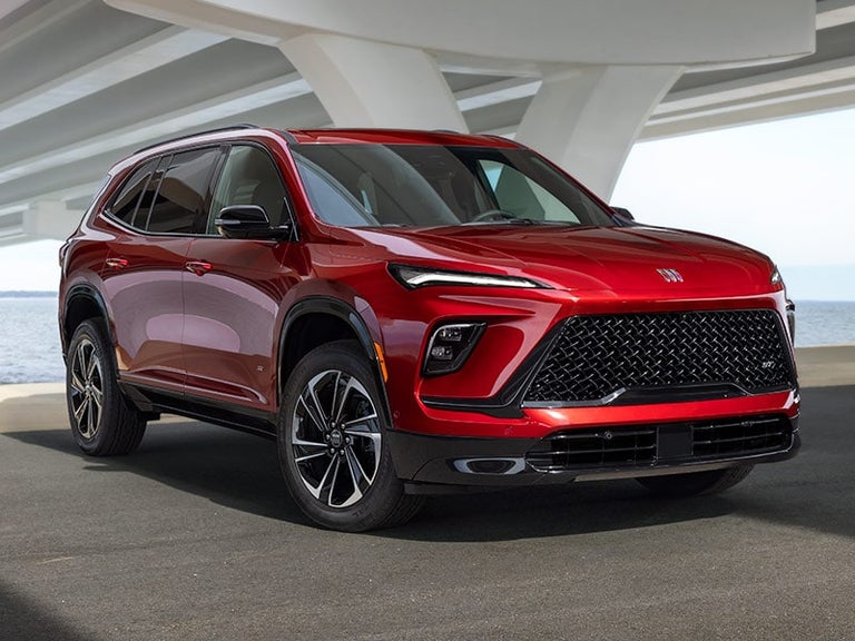 Three-Quarters View of a Red 2025 Buick Enclave ST Under a Bridge