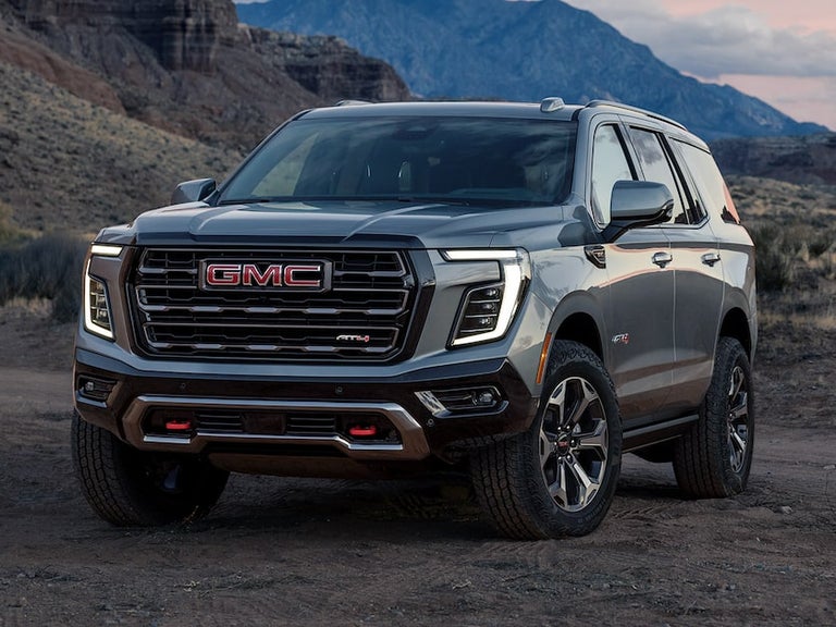 Front Three-Quarter View of the GMC Yukon Large SUV Parked in the Desert at Sunset